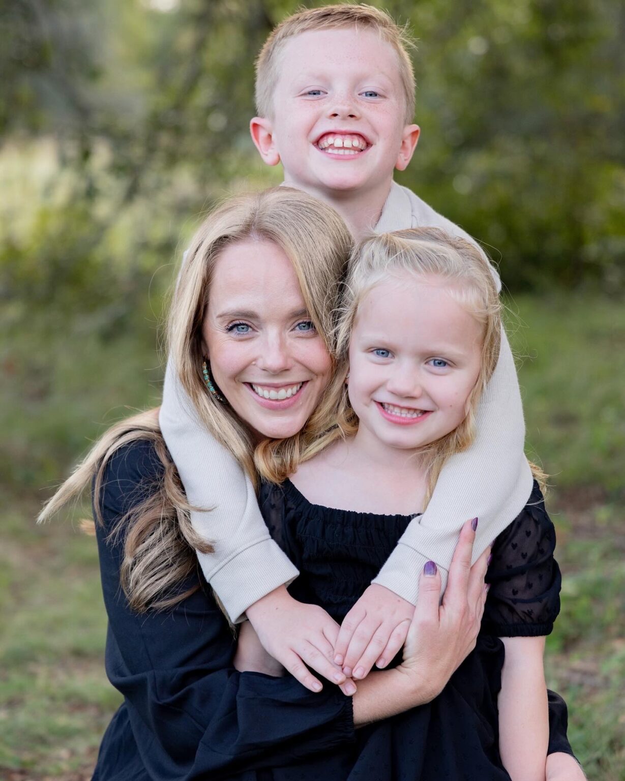 blonde mother hugged by children a boy and a girl